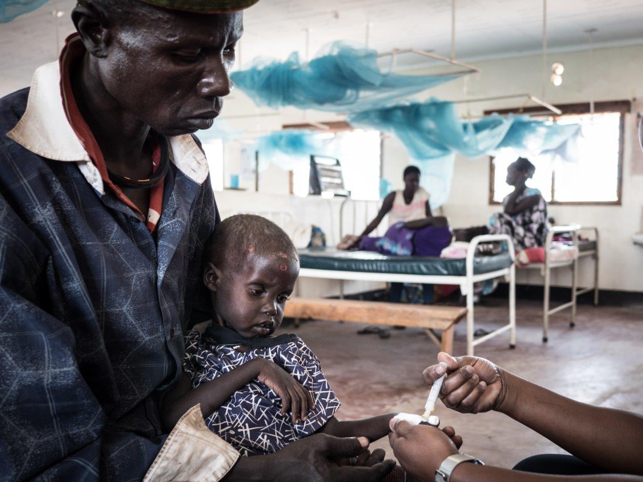 Turkana mit seiner an Malaria leidenden Tochter im von den Johannitern betriebenen Krankenhaus von Kakuma (Credit: Aktion Deutschland Hilft /Roland Brockmann)
